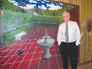 By Christina Corrales-Toy Artist Dan Meredith stands by a courtyard scene he painted on one wall of the pool room at Regency Newcastle.