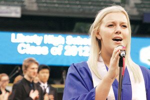 By Greg Farrar Alexis McGinnis sings the National Anthem as the Safeco Field scoreboard welcomes the Liberty High School Class of 2012.