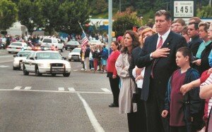 By Autumn Koepp Mayor John Dulcich stands with hundreds of mourners as they watch a procession of more than 450 police vehicles drive through Newcastle in honor of fallen Deputy Richard Herzog in 2002.