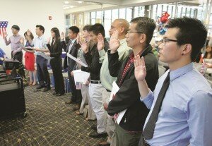 By Greg Farrar Immigrants from around the world, who passed citizenship tests and renounced allegiances to the countries of their birth, take the oath of allegiance from officials of the United States Citizenship and Immigration Services July 23 during a naturalization ceremony at the Newcastle Library.