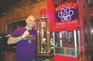 By Christina Corrales-Toy Chris Mendez, head coach of the University of Washington boxing team, shows off the team's national championship trophy in his Newcastle home.