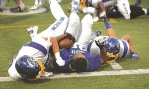 By Greg Farrar Russell Boston (middle), Liberty High School senior running back, lies on the turf without his helmet after being tackled by Parker Trewet (left) and Kevin Govea of Hazen on the HighlandersÕ 11-yard line during the second quarter. The Patriots won the rivalry of Renton Highlands schools, 56-6.