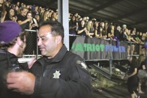 By Greg Farrar Deputy Dave Montalvo, Liberty resource officer, is greeted warmly by a visiting graduate near the grandstand student section as he patrols a Sept. 12 football game.