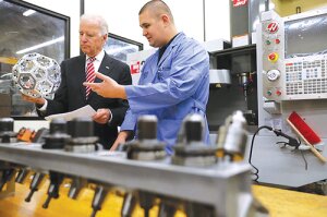 By Ken Lambert / The Seattle Times Vice President Joe Biden (left) holds a machined object as he talks to instructor Adam Pohlman during a tour of Renton Technical College.