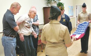By Kathleen R. Merrill World War II veteran Gordon Schumacher, 91, is helped by his sons Dale (left) and Dean as Liberty NJROTC members Emily Magley (with her back to the camera) and Tina Kaiser fold his flag while the VFW’s Dave Waggoner (in hat) looks on.