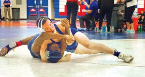 Derek Nichols, Hazen High School senior (top), wrestles Beamer High School's Malik Ford.