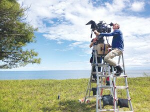 Contributed Alex Bell (right) scales a ladder to get the shot in a scene for his film ‘Superior,’ set in Michigan.