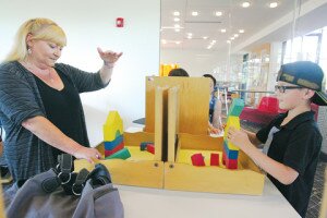 By Greg Farrar Alisha McKenzie (left) and her grandson Brian Groeneveld, 8, both of Newcastle, play ‘Tell Me About It,’ a verbal linguistic communication game where one builds a skyscraper with blocks and describes it for the partner to duplicate without looking. View a full gallery of Brain Science photos here.