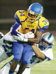 By Greg Farrar Kaleb Magee (34), Hazen High School senior running back, runs the ball against Sam Harrington (left) and Alex Olague, of Liberty, during the third quarter of their Sept. 11 football game at Renton Stadium.
