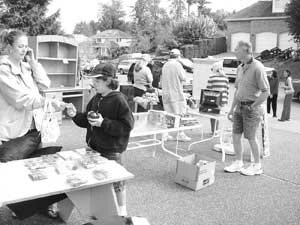 garage-sale-newcastle-bw Shoppers check out the merchandise at a recent Olympus neighborhood garage sale. Contributed