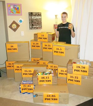 Contributed Sam Catherall, a Maywood Middle School eighth-grader, stands among the 576 pounds of canned and nonperishable food he collected for his school’s annual food drive.