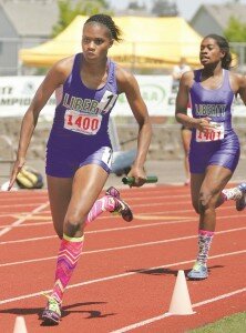 By Greg Farrar Cherelle Demps (left), Liberty High School junior, anchors the 4x100 relay race after taking the baton from twin sister Danielle in the state 3A championships May 31.