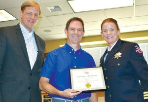 By Christina Corrales-Toy Newcastle resident Jeff Garlock (middle) is flanked by Mayor Steve Buri and Police Chief Melinda Irvine after he received a certificate for helping police take a bite out of crime at the Aug. 19 City Council meeting.
